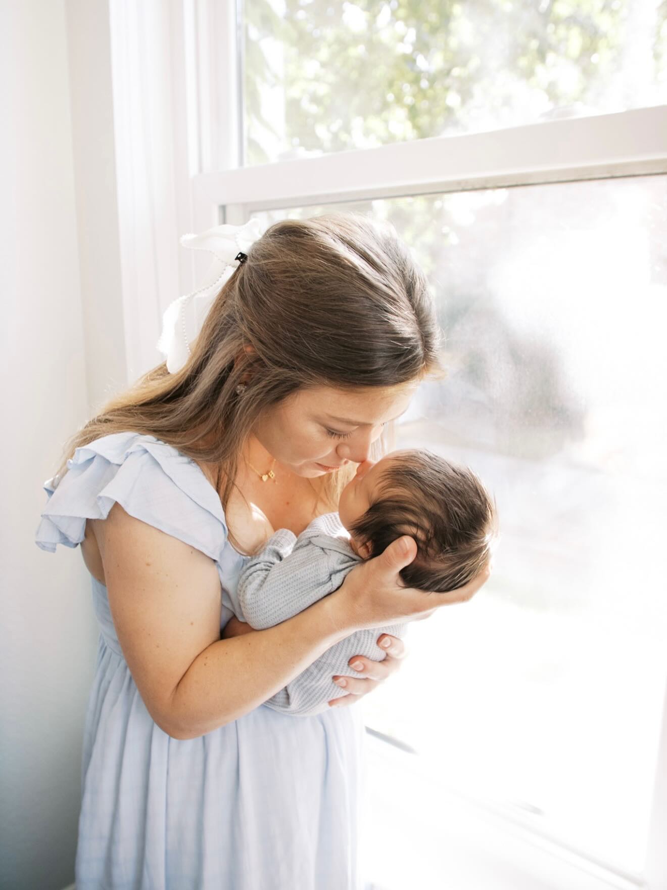 a mother with her newborn son by a window