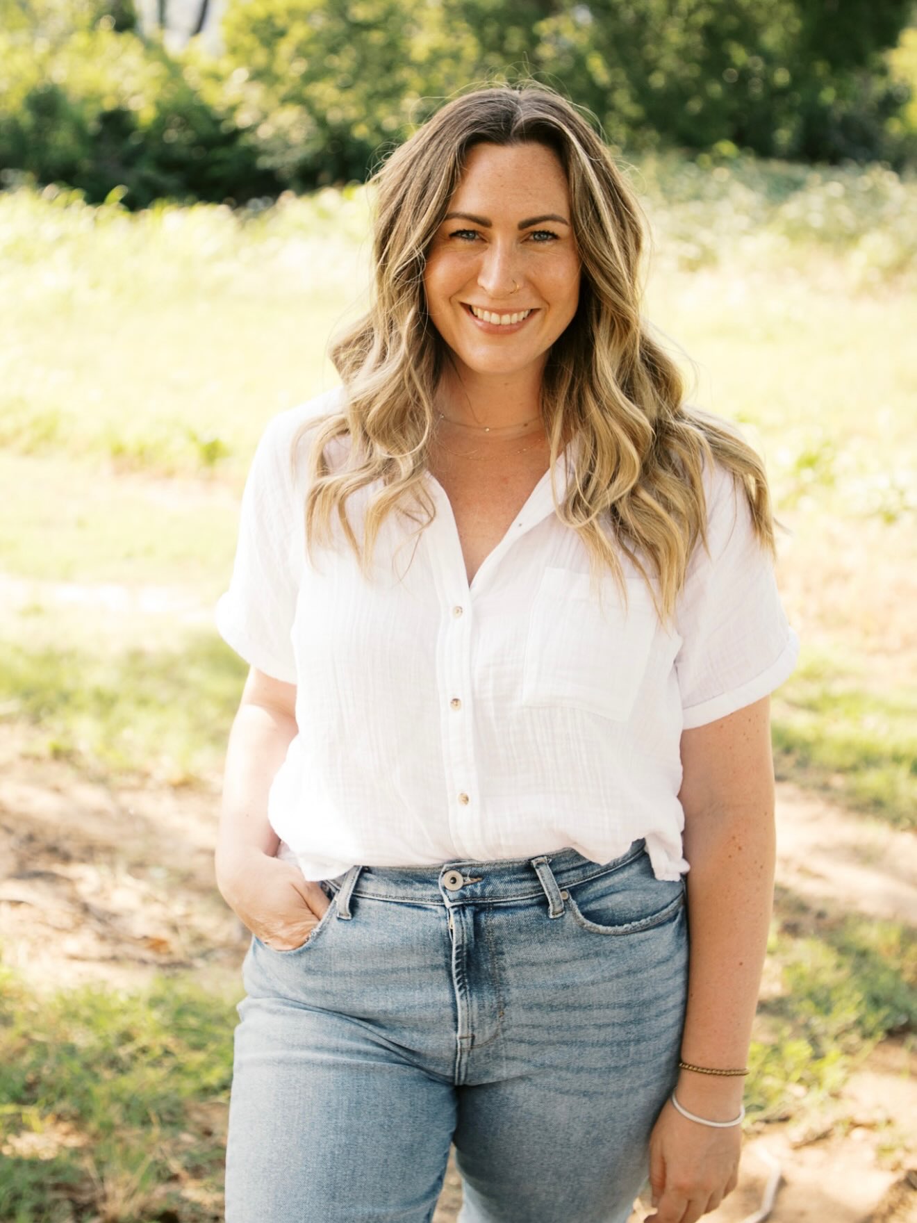 a doctor with her hand in her pocket in a beautiful field
