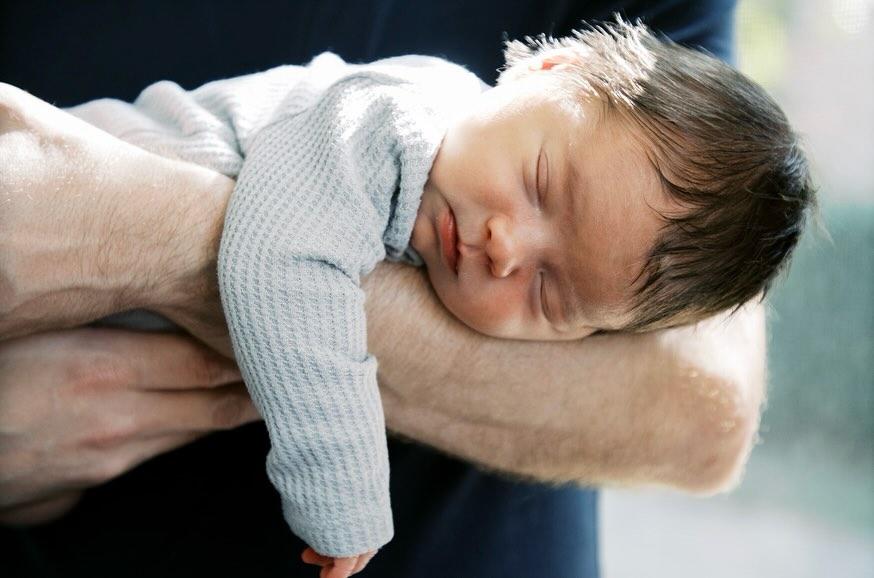 a beautiful newborn boy laying on his fathers forearm
